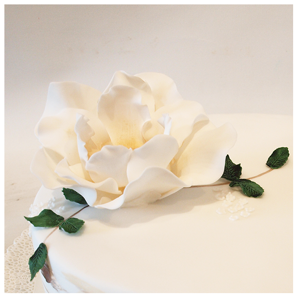 Stor hvid magnolia med sm grnne blade. Hndlavet sukkerblomst og blade